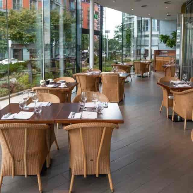 Stylish dining area with wicker chairs at Scoff & Banter, perfect for upscale events.