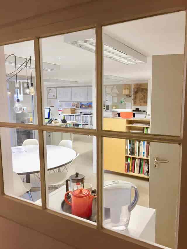 Versatile meeting room with round table in bright Busworks studio for creative events.