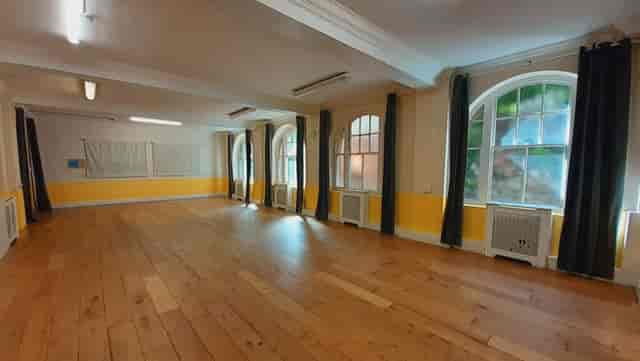 Spacious Mycenae House event space with large windows, ideal for workshops and meetings.