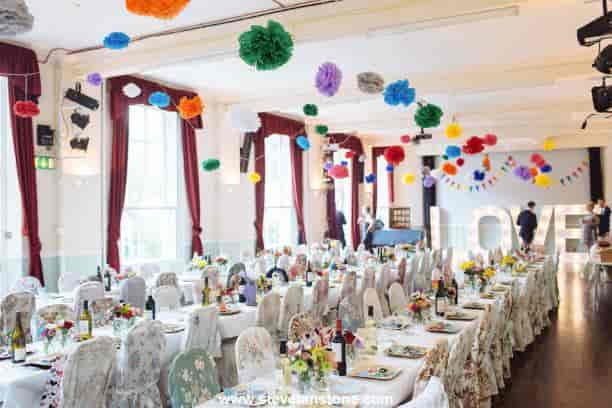 Café Bar in Mycenae House, decorated for a wedding with vibrant pom-poms and floral centerpieces.
