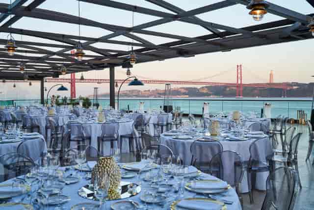 Elegant outdoor dinner setup at Lisboa Hall, featuring sunset views and fine dining.