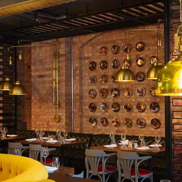 Kibele Restaurant dining area with warm brick wall, perfect for corporate events and gatherings.