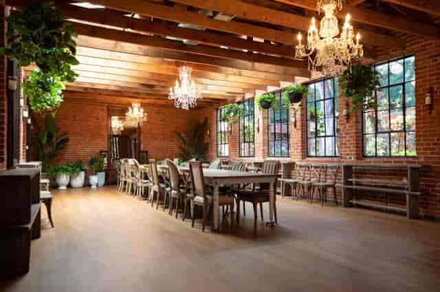 Carondelet House event space with exposed brick and elegant chandeliers for gatherings.