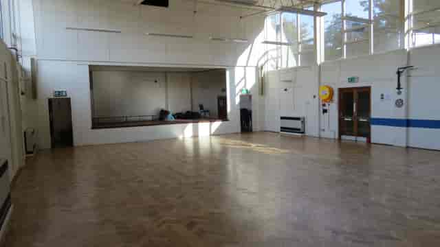Spacious meeting room with wooden flooring for workshops and social gatherings.