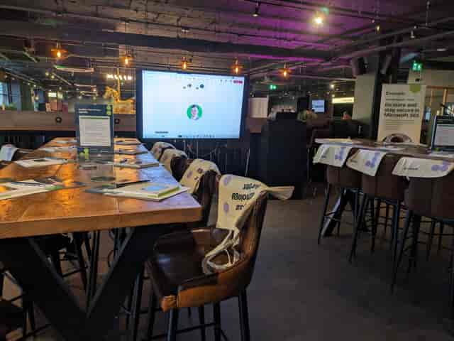 Modern meeting space in Par 59 Bristol with long tables and a large presentation screen.