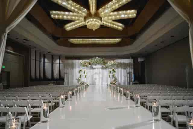 Elegant wedding ceremony setup in Vineyard Room with floral backdrop and chandelier.