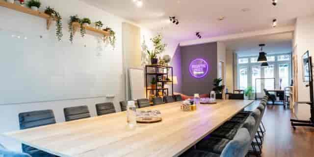Modern meeting space with wooden table, ideal for workshops and team meetings.