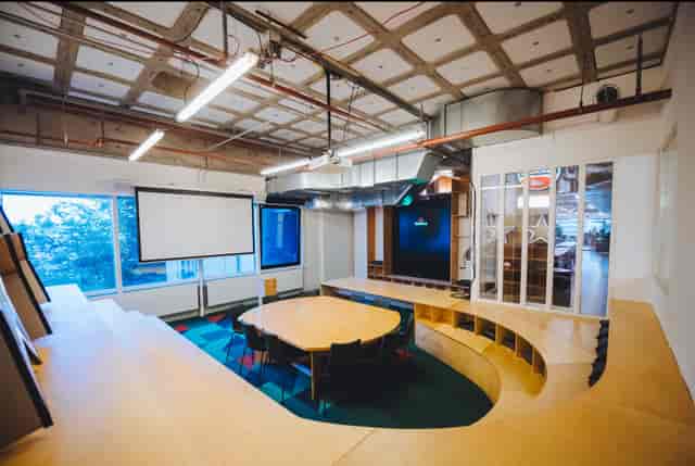 Modern meeting space with circular table and natural light in B. Amsterdam for collaboration.
