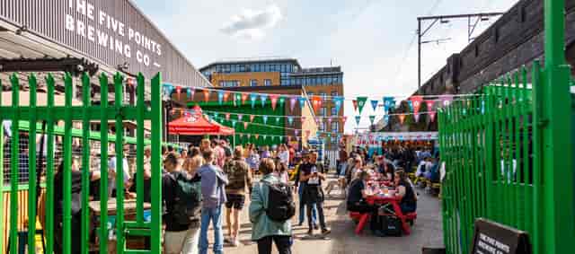 Vibrant outdoor event space at Five Points Taproom with colorful bunting for gatherings.