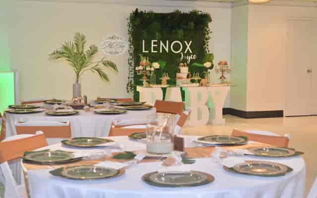 Banquet hall with elegant green decor for a baby shower celebration.
