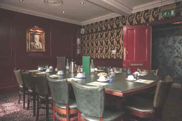Elegant meeting room with dark wood paneling, ideal for executive gatherings and discussions.