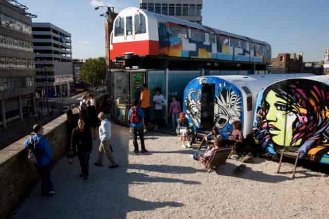 Vibrant urban venue with repurposed train cars for creative workshops and networking events.