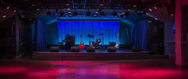 Main floor bar stage with blue backdrop, ideal for live concerts and events.