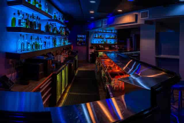 Sleek modern bar with blue lighting, perfect for networking events and cocktail receptions.