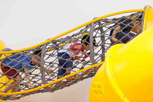 Children exploring a colorful play structure at South Play for engaging team-building events.