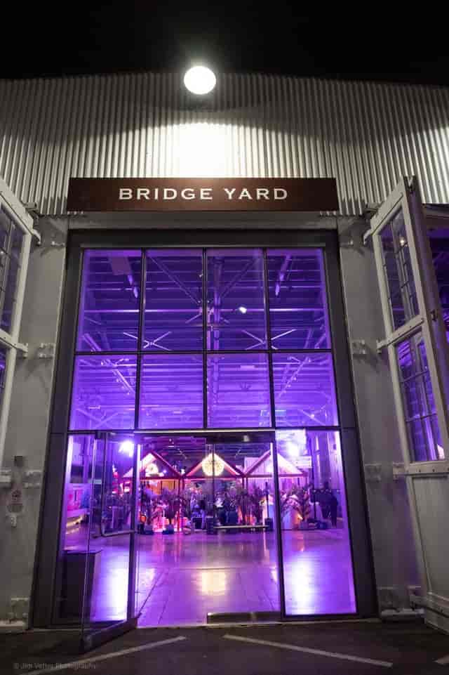 Outdoor courtyard entrance at The Bridge Yard with purple lighting for vibrant events.