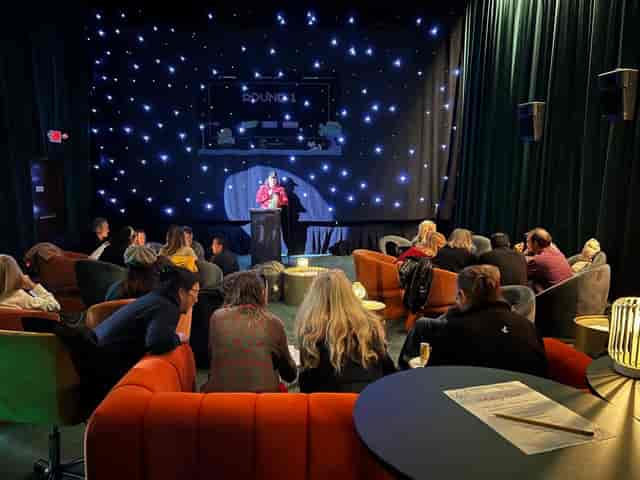 Cozy Cinelounge restaurant event space with speaker, ideal for workshops and networking.