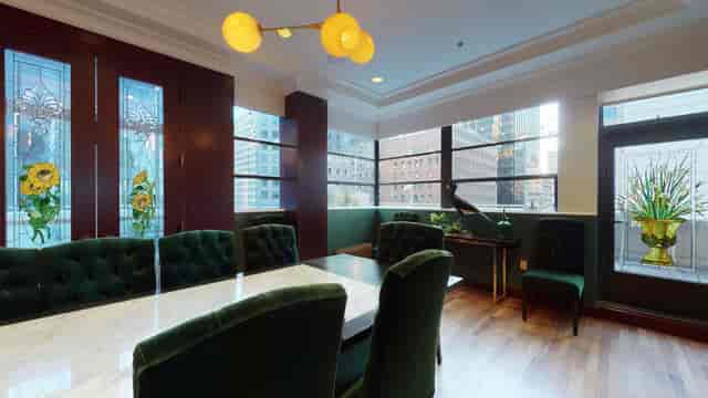 Sophisticated conference room with marble table and plush green chairs for meetings.