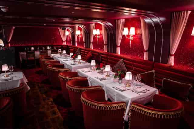 Elegant semi-private dining area with rich red decor for upscale events and intimate gatherings.