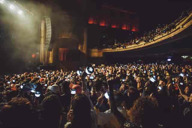 Vibrant crowd at The Warfield concert, illuminated by smartphones, showcasing audience engagement.