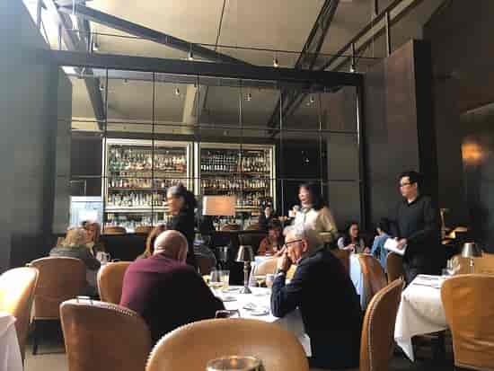 Sophisticated cafe dining setting for corporate events with elegant tables and bar.