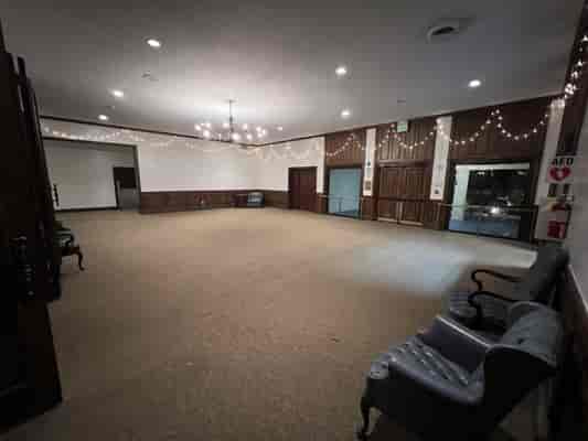 Main Room at Albert H. DeWitt Officers' Club, spacious venue with elegant chandeliers for events.
