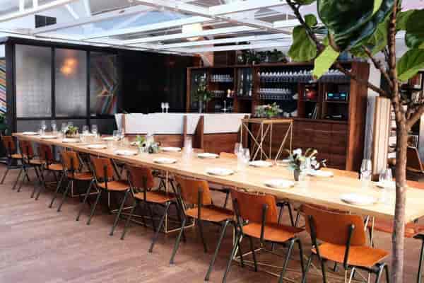 Californian restaurant event space with wooden table, ideal for intimate gatherings and corporate dinners.