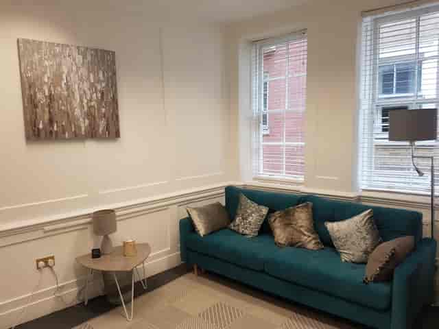Cozy meeting space with teal sofa, ideal for informal gatherings and brainstorming sessions.