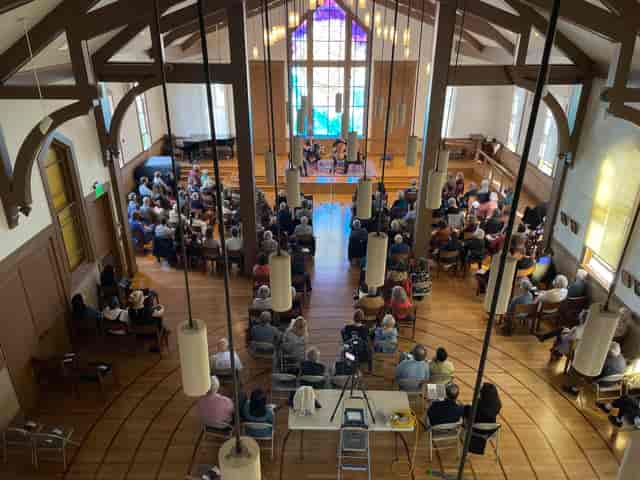 Noe Valley Ministry event with attendees in semi-circle, bright and engaging atmosphere.