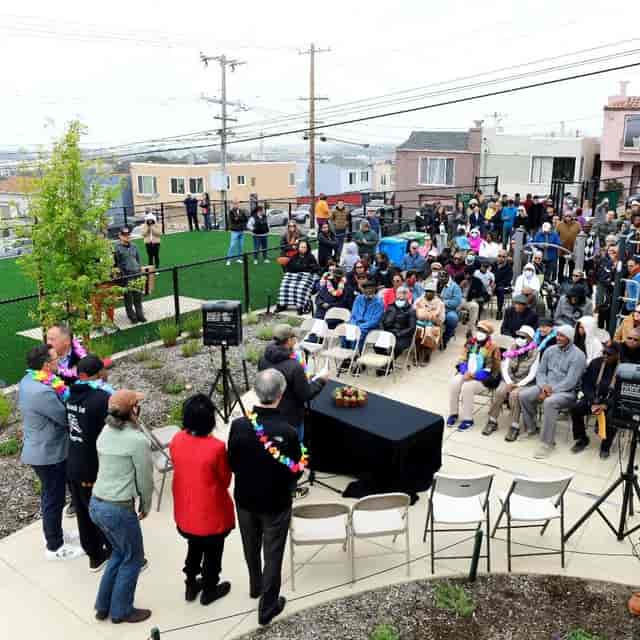 Outdoor community event at The Playground in Folsom Street with diverse attendees and stage.