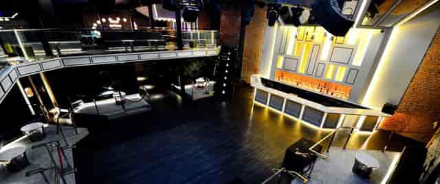 Versatile event space with sleek bar, ideal for corporate gatherings and social events.
