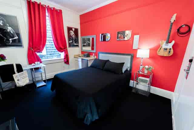 Stylish conference hall with red accent wall, ideal for creative meetings and retreats.