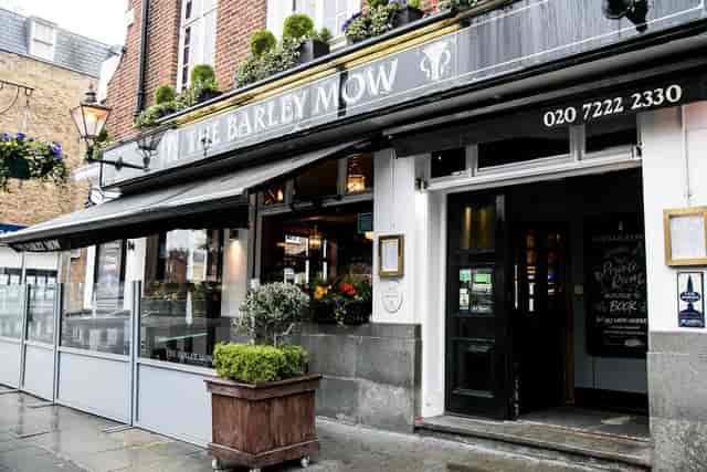 Charming pub exterior with outdoor seating, ideal for casual meetings and social events.