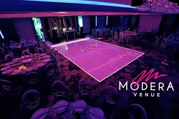 Elegant Modera Ballroom with round tables, perfect for weddings and corporate events.