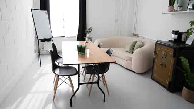 Modern meeting space in Bijou Room, featuring a wooden table for team collaboration.