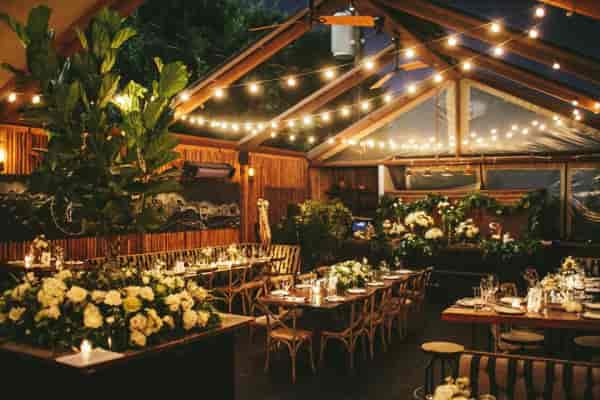 Elegant event space with floral tables and string lights at The Eveleigh's Front Patio.