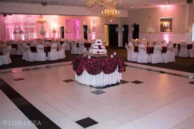 Elegant banquet hall setup for weddings with soft lighting and centerpiece cake.