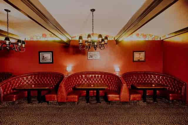 Cozy meeting space with plush red booths at Long Beach Petroleum Club for networking events.