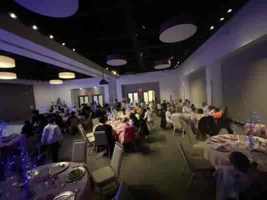 Sweet 16 celebration in modern banquet hall with elegant decor and ambient lighting.