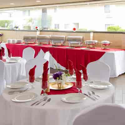 Elegant event space at Olive's Bistro with red and white decor for memorable dining experiences.