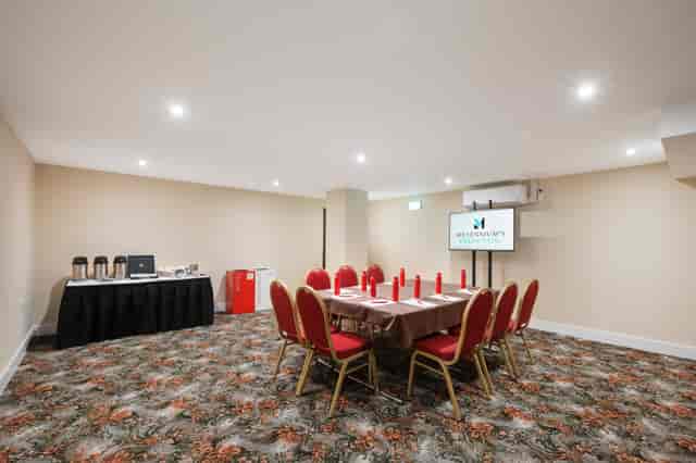 Windsor Suite meeting room with round table, red chairs for workshops and conferences.
