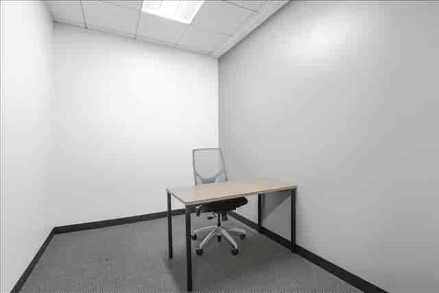 Minimalist meeting room with desk and chair for intimate discussions or brainstorming sessions.
