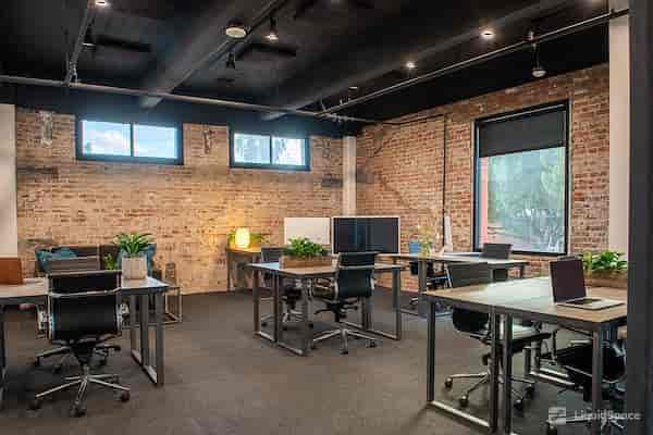 Modern flexible workspace with exposed brick, ideal for meetings and events.
