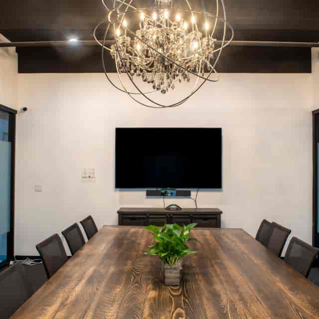Modern rentable meeting room with wooden table, ideal for corporate events and presentations.