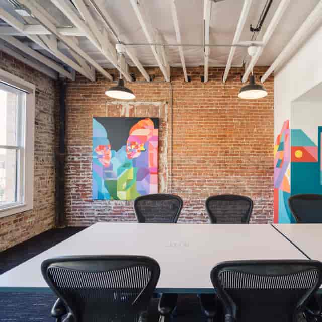 Modern rentable meeting room with exposed brick walls for creative workshops.