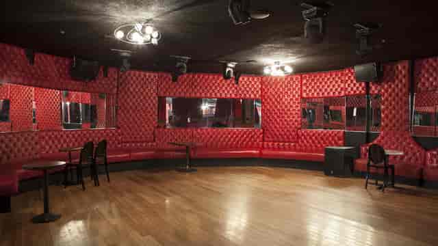Stylish event space with red tufted walls, perfect for private parties and gatherings.