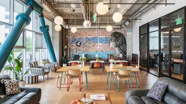 Modern coworking space with vibrant mural, ideal for meetings and events.