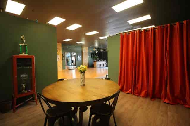 Practice Parties at Arthur Murray Dance Studio with round table and vibrant orange curtains.