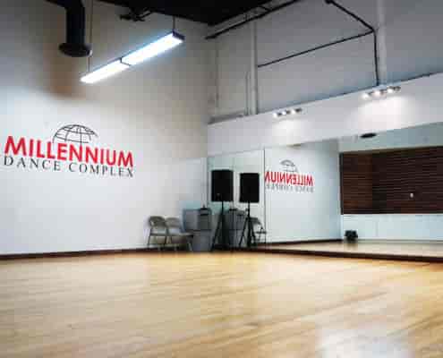 Versatile dance studio with wooden floor and mirrors for events and workshops.