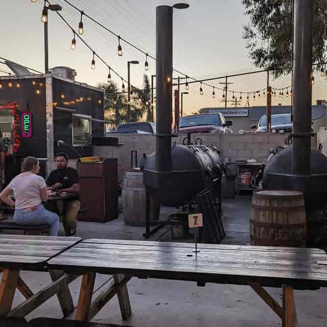 DJ Krispy at Club Marina's cozy outdoor BBQ event with rustic decor and warm lighting.